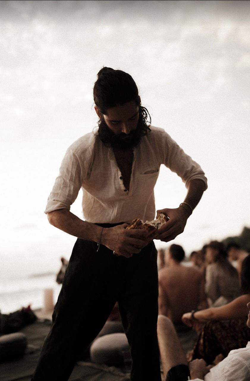 The founder breaking bread at sunset on the beach during a retreat